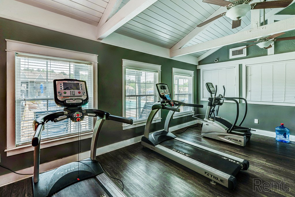 a home gym with exercise equipment and windows