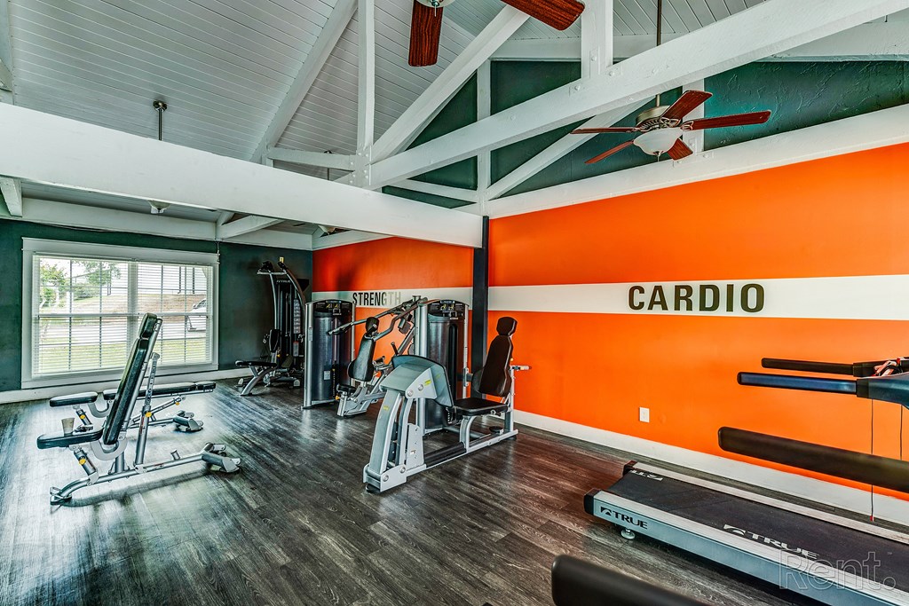 the home gym has plenty of exercise equipment and a large window
