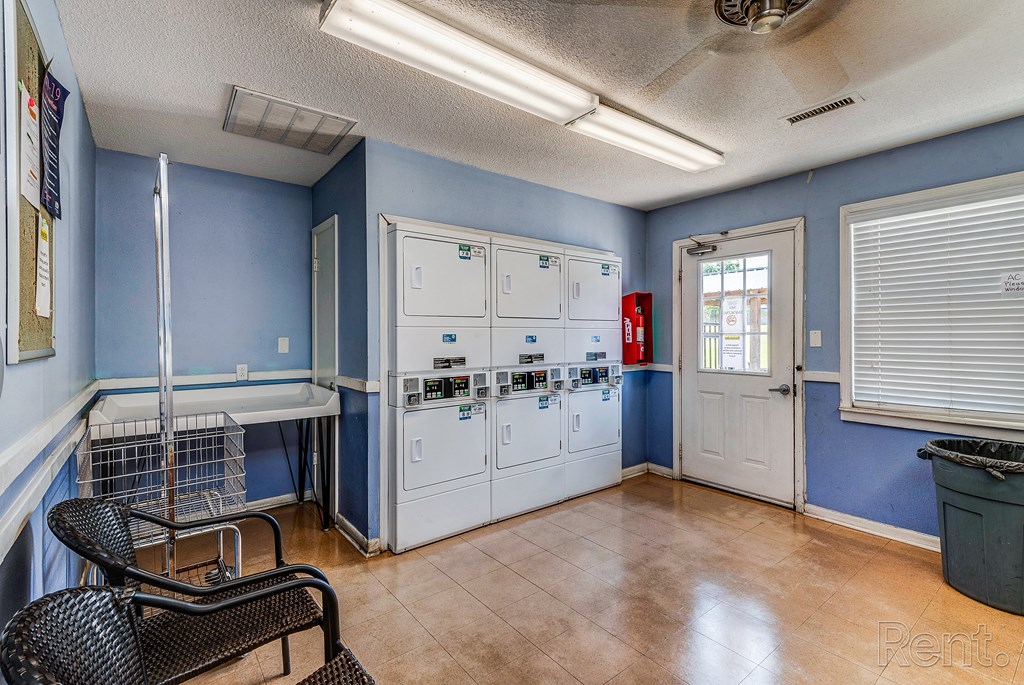a room with blue walls and white cabinets and a table and chairs