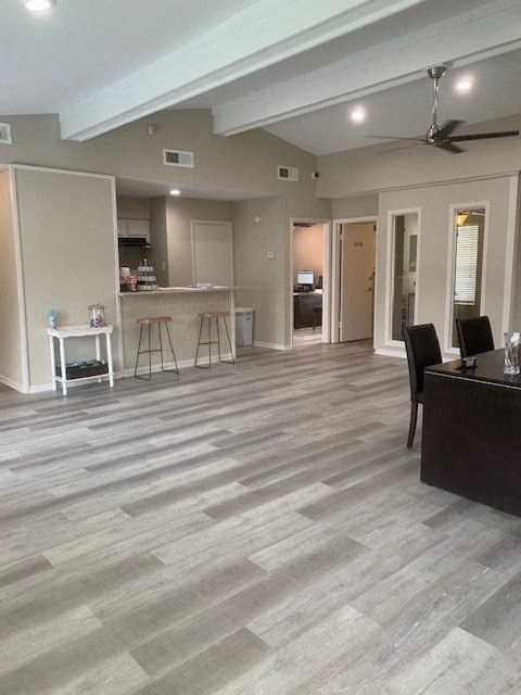 a living room with a kitchen in the background