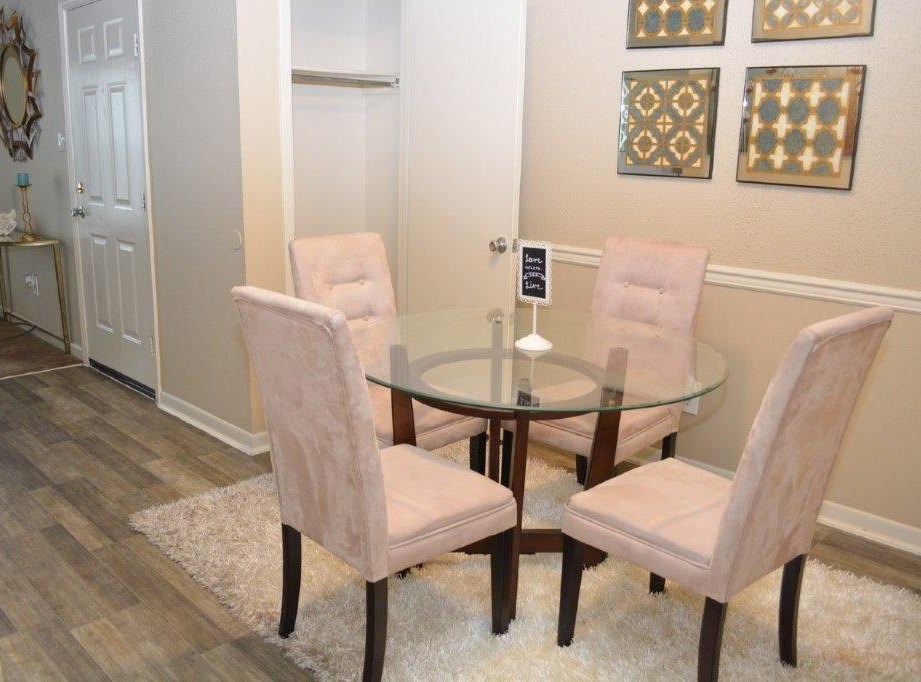 A glass table with four chairs around it.