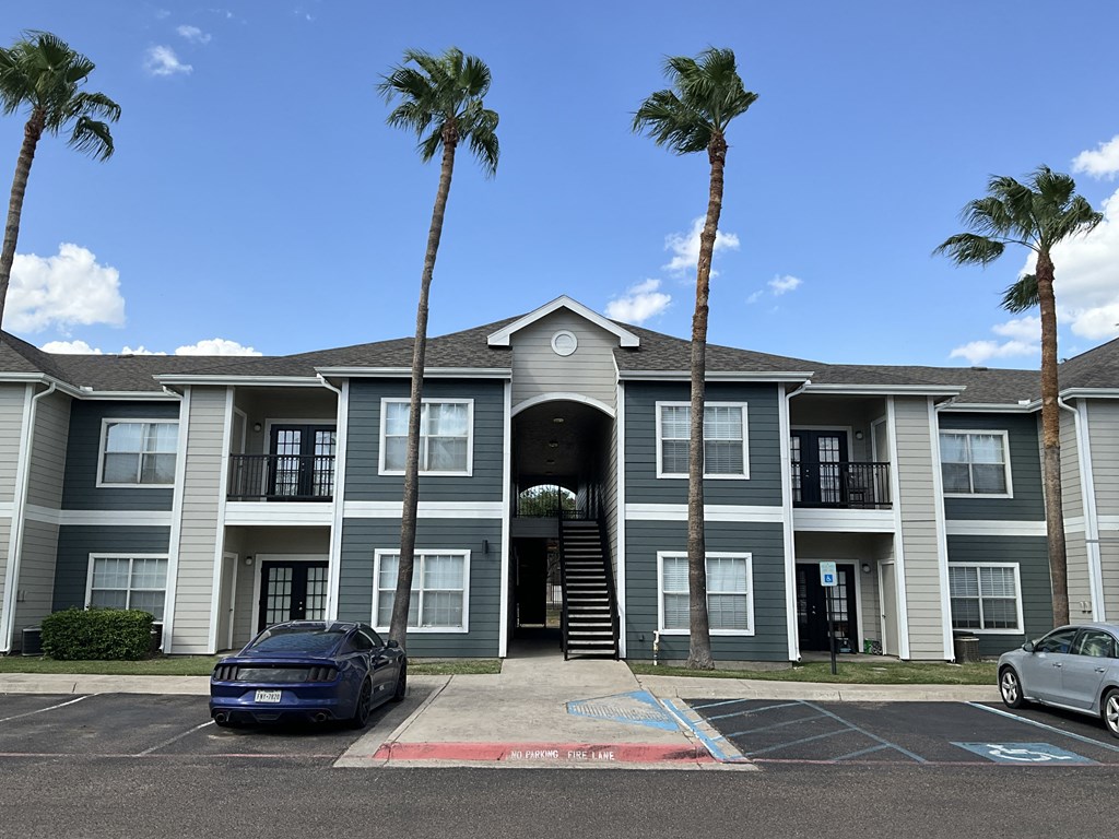 a large apartment building with palm trees in front of it