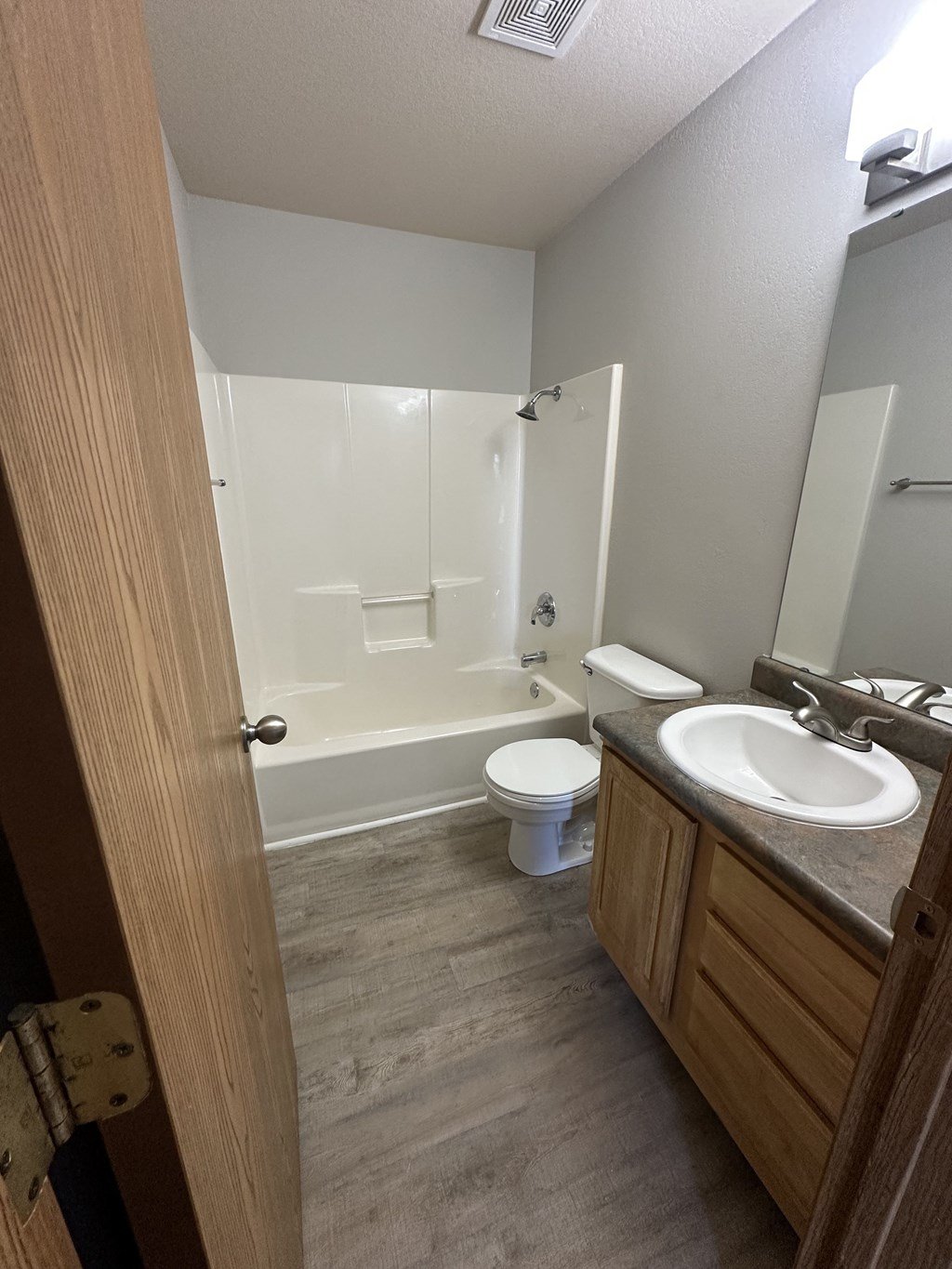 an open door leading into a bathroom with a toilet sink and tub