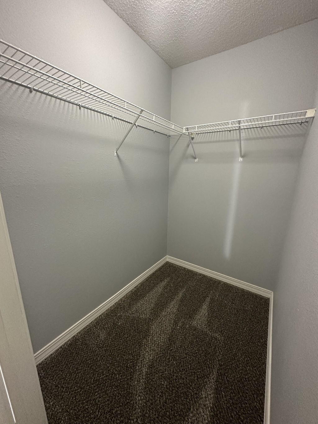 a small empty room with a wire rack hanging on the wall