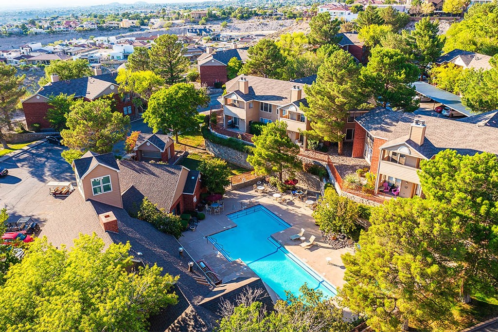 A bird's eye view of a residential area with houses and a swimming pool.