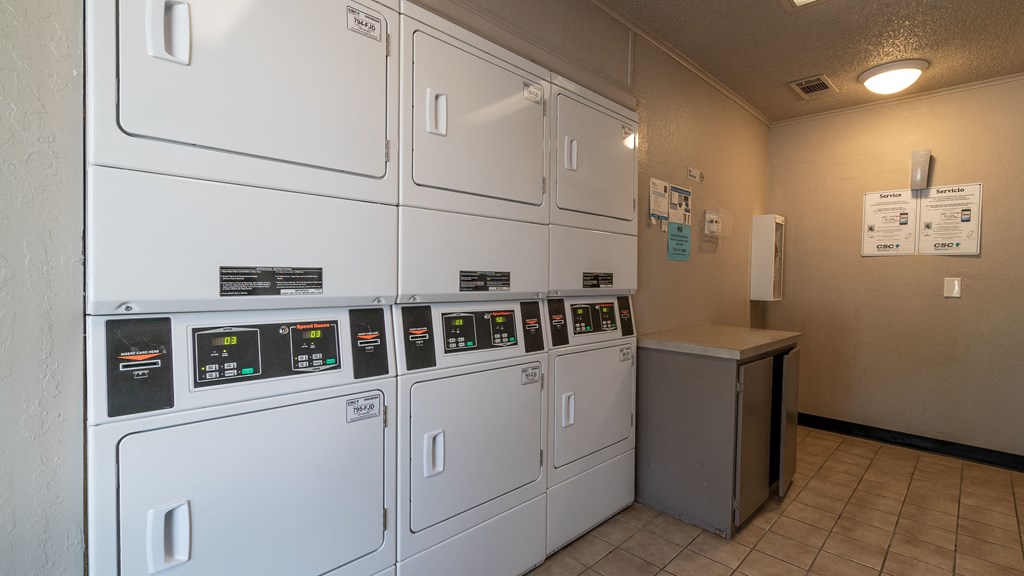a row of washers and dryers in a laundry room