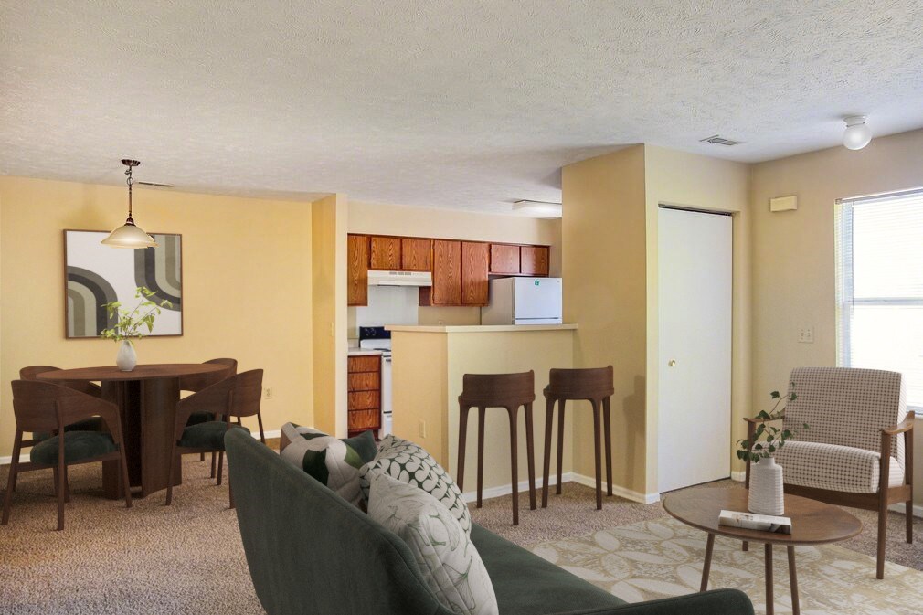 A living room with a grey couch and a wooden dining table.