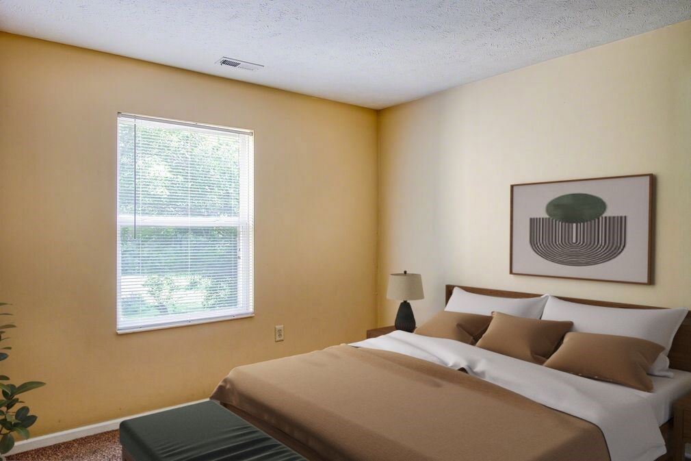 A bedroom with a bed, lamp, and a painting on the wall.