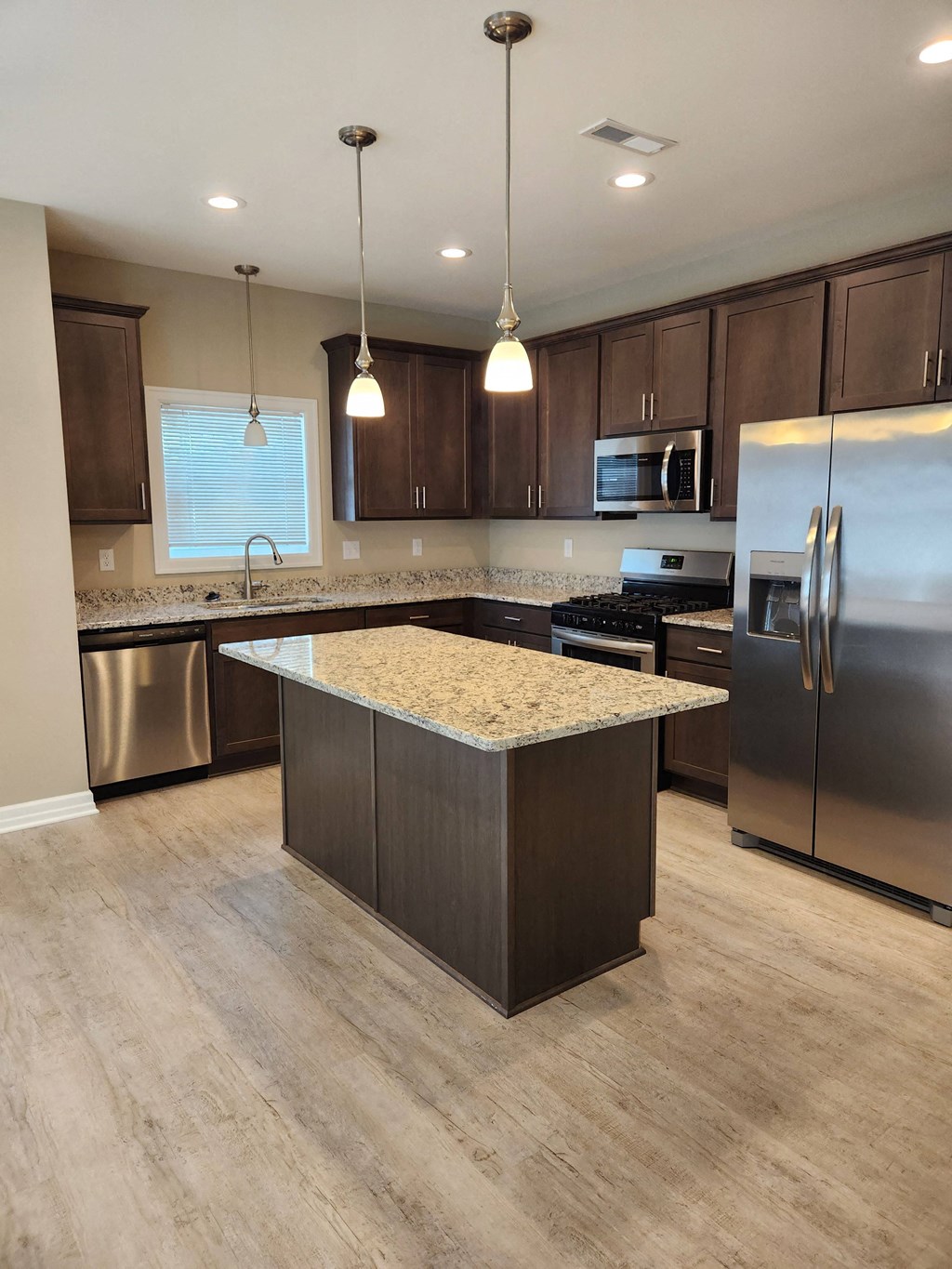 a kitchen with stainless steel appliances and a marble counter top