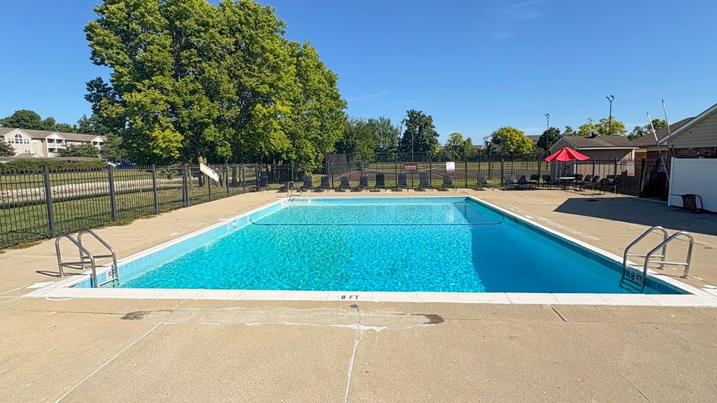 A large outdoor swimming pool surrounded by a fence.