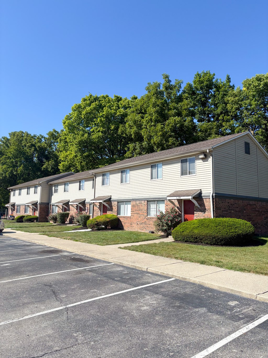 A row of houses with a parking lot in front.