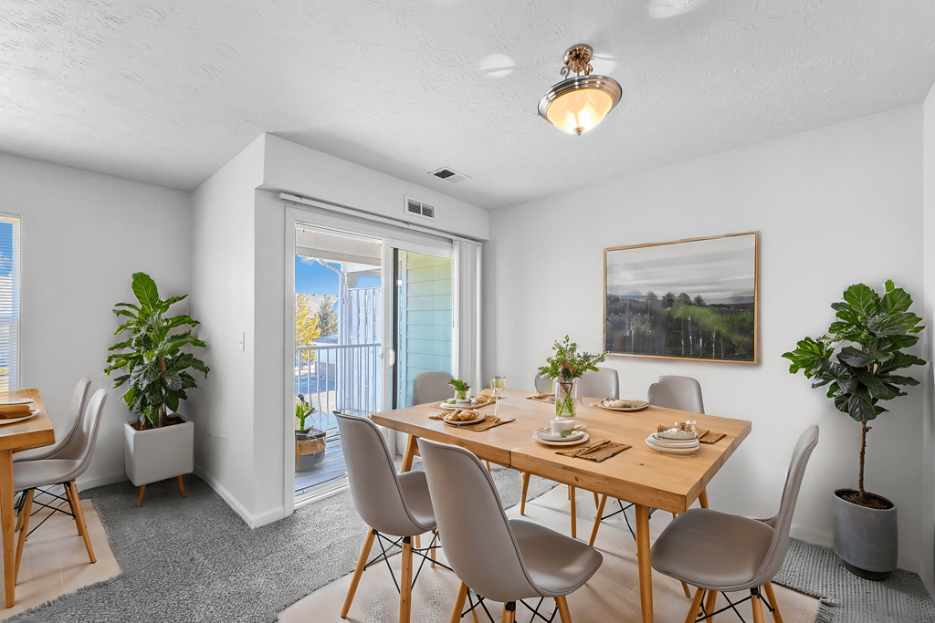 A dining room with a wooden table and chairs.
