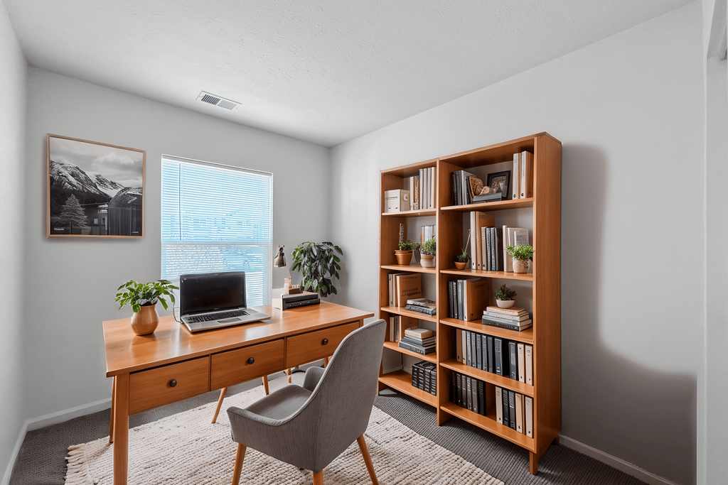 A room with a desk, chair, and bookshelf.