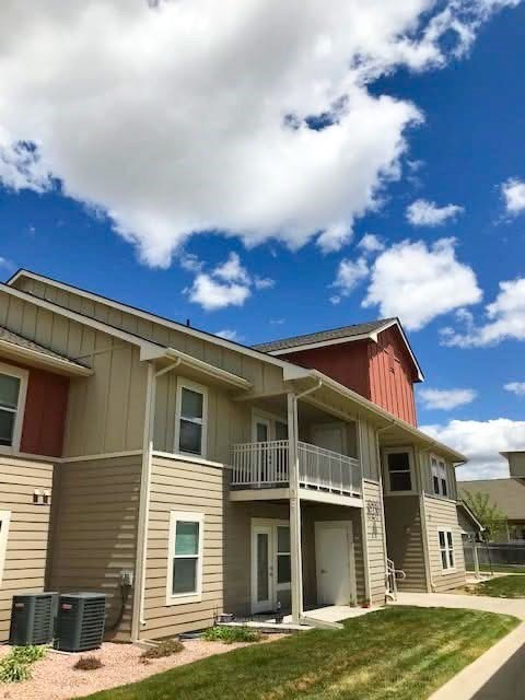 A row of houses with a blue sky and clouds above.