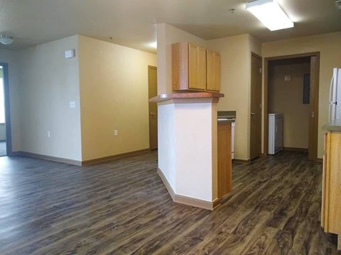 A kitchen area with wooden cabinets and a refrigerator.