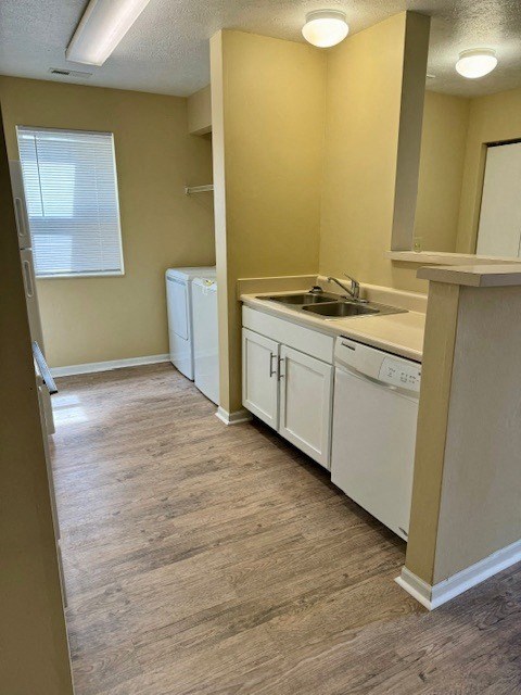 an empty kitchen with white cabinets and a sink