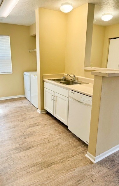 A kitchen with white cabinets and a sink.