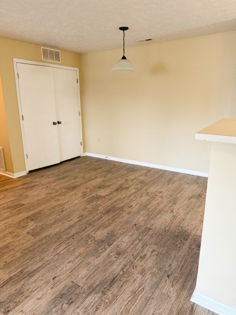 A room with a white door and a light brown floor.