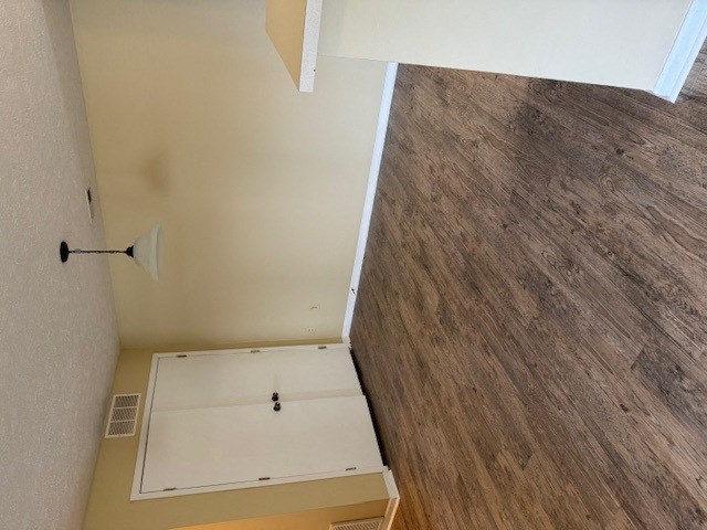 an empty room with a closet and a wood floor