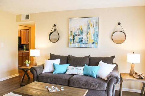 A grey couch with blue and white pillows in a living room.