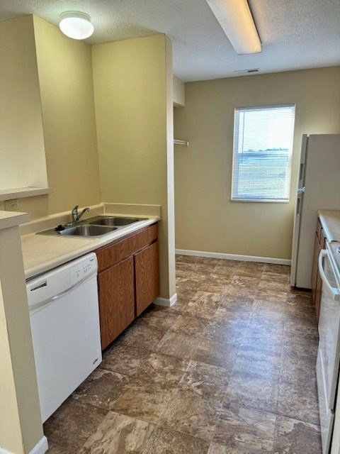 an empty kitchen with a sink and a refrigerator