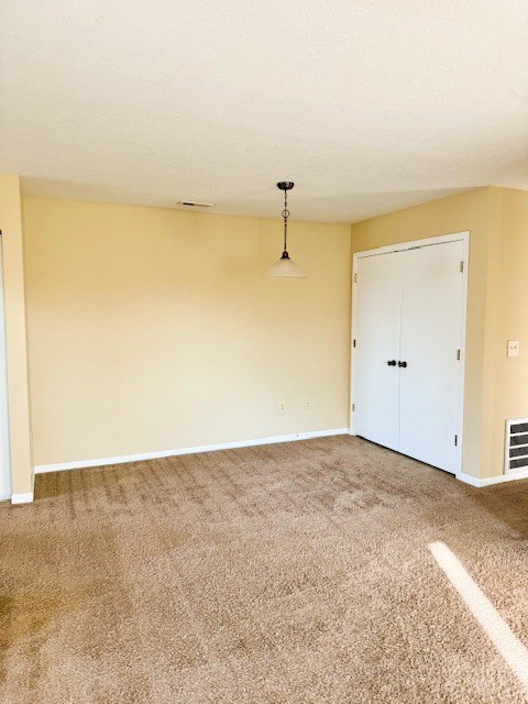 A room with a white door and a carpet on the floor.