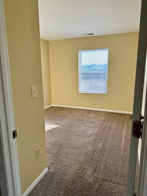 an empty room with carpet and a window