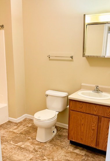 A white toilet sits next to a sink in a bathroom.