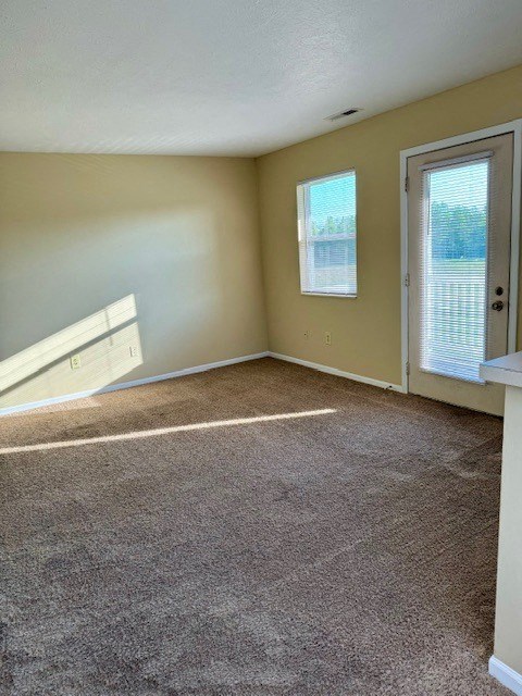 an empty room with carpet and a door