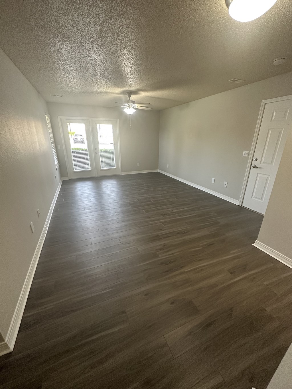 an empty living room with a hardwood floor