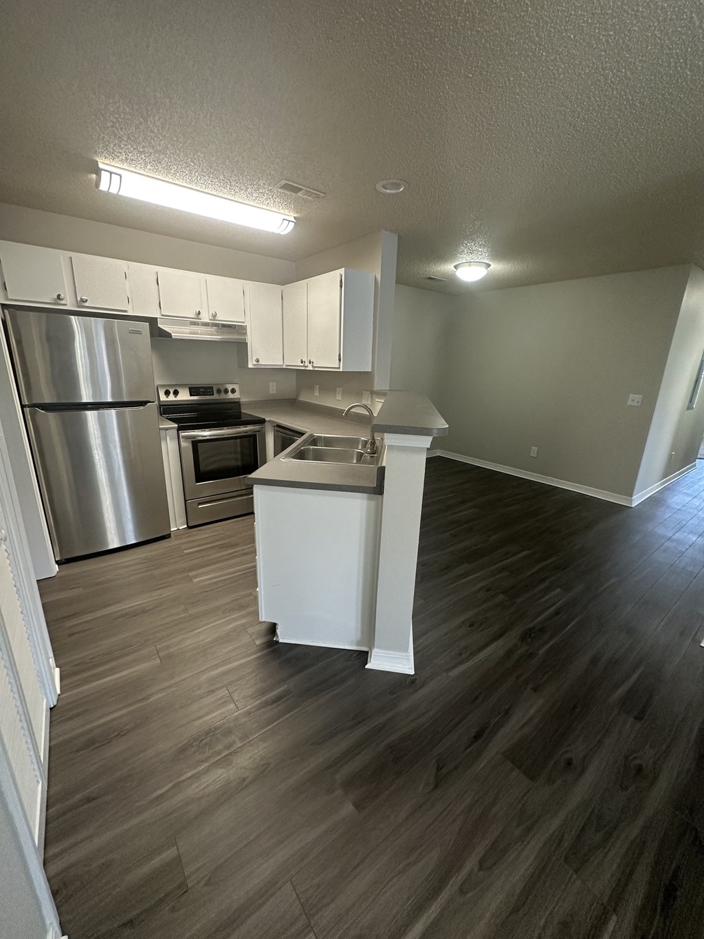 an open kitchen with white cabinets and stainless steel appliances