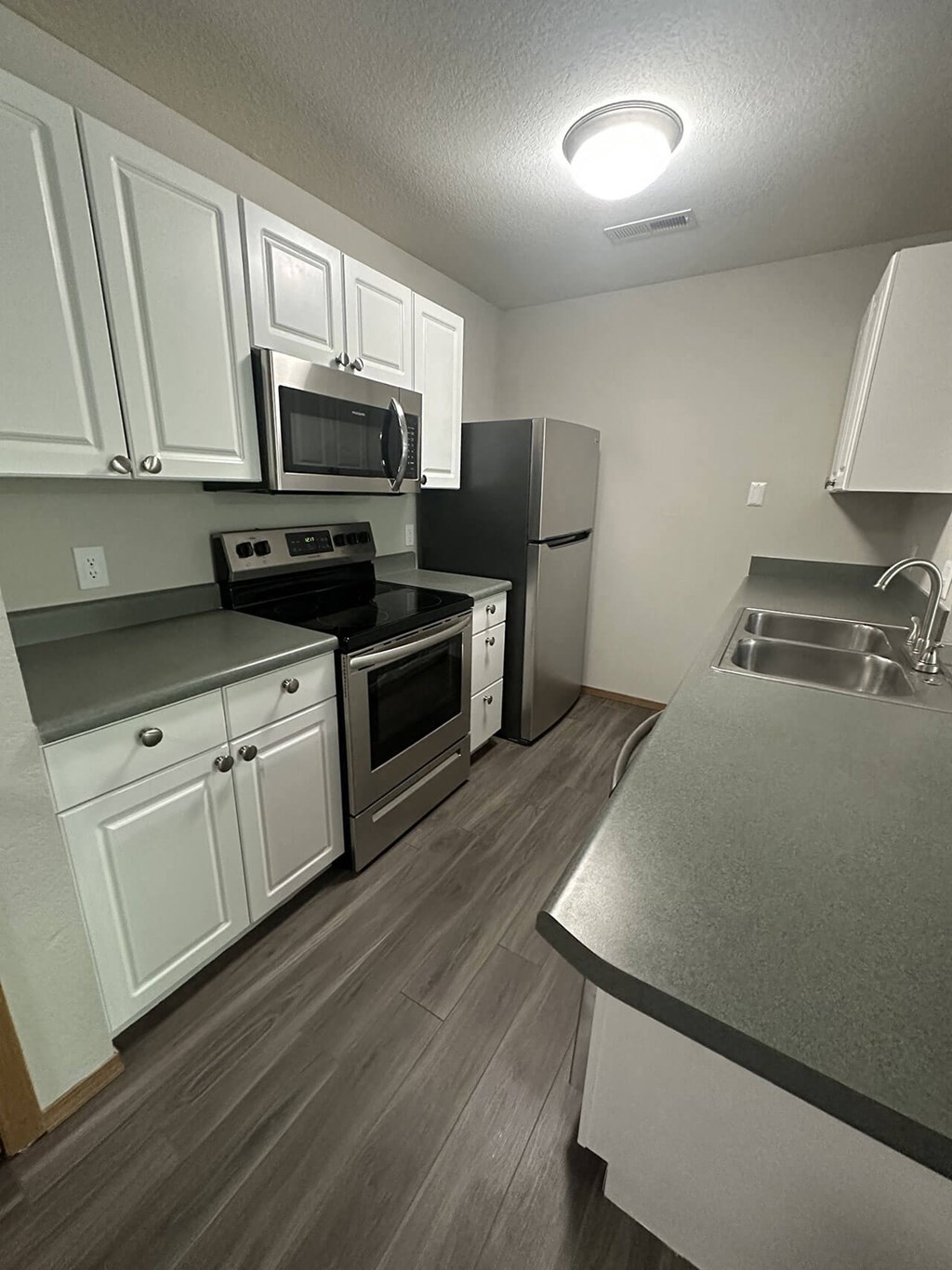 a kitchen with stainless steel appliances and white cabinets
