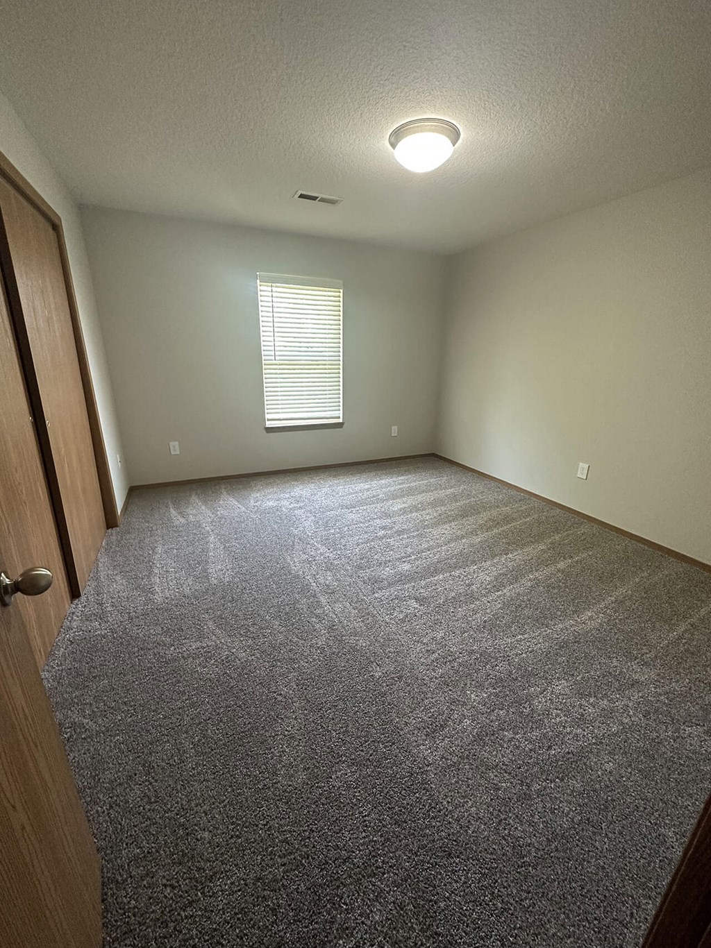 a room with a carpeted floor and a window