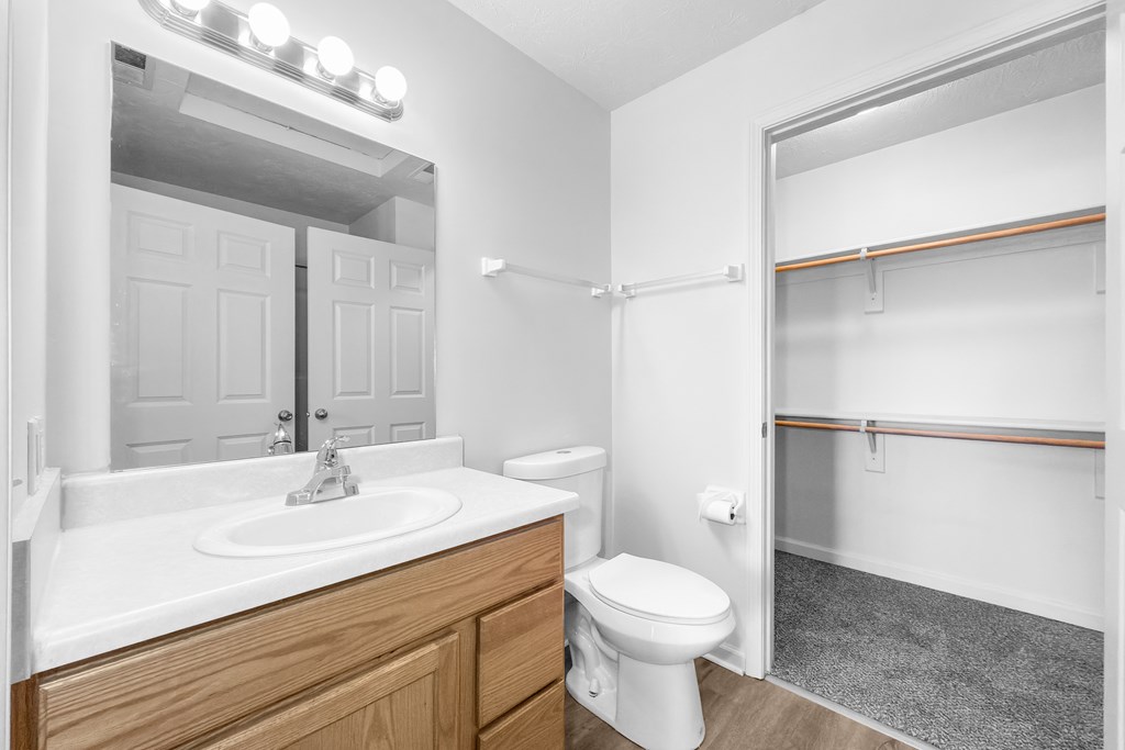 A white bathroom with a sink, toilet and mirror.