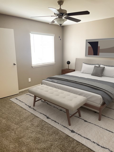 A bedroom with a large bed and a ceiling fan.