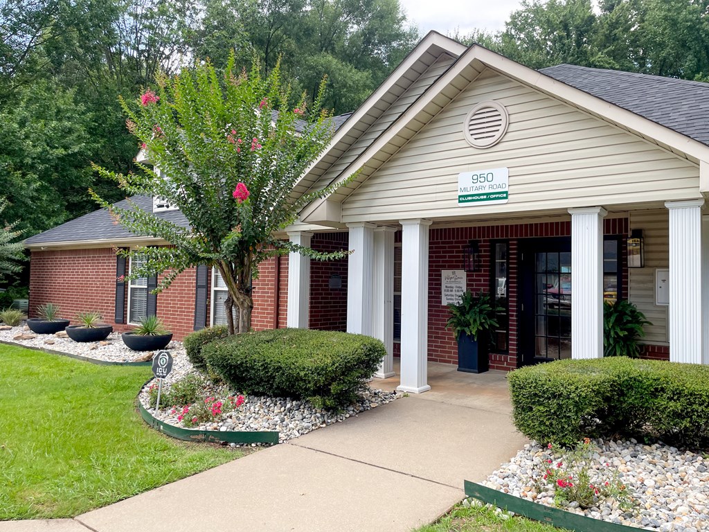 A building with a sign that reads 950 is in front of some trees.