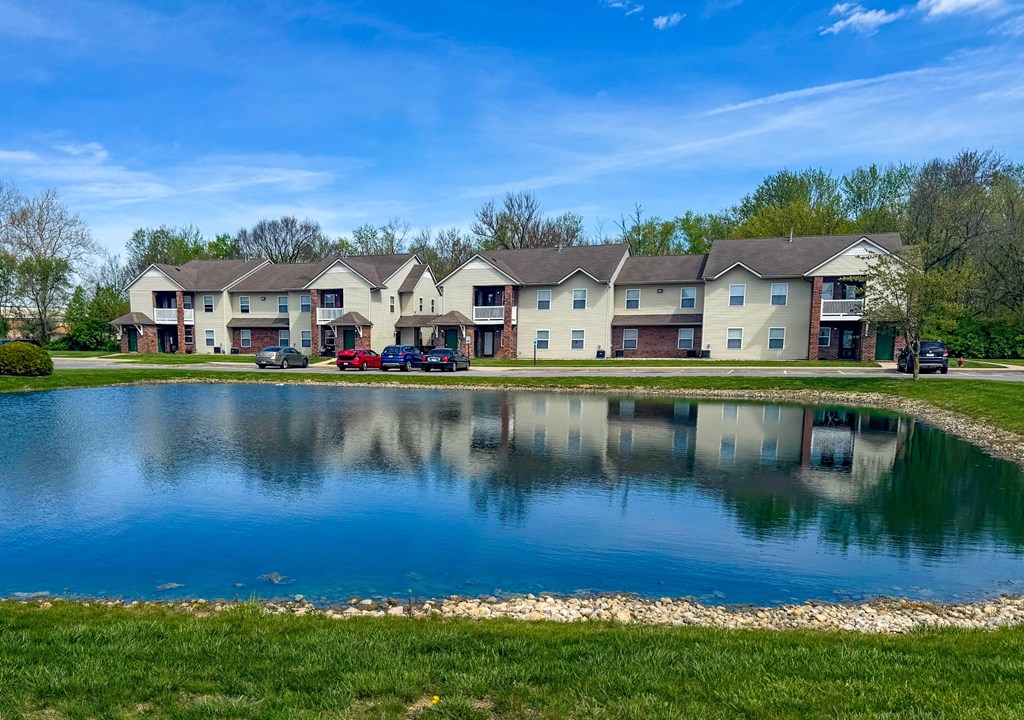 A row of houses with a pond in front.