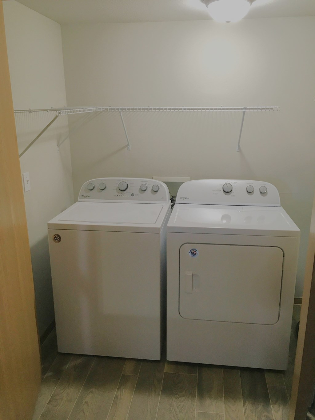 Two white front loading washing machines in a small laundry room.