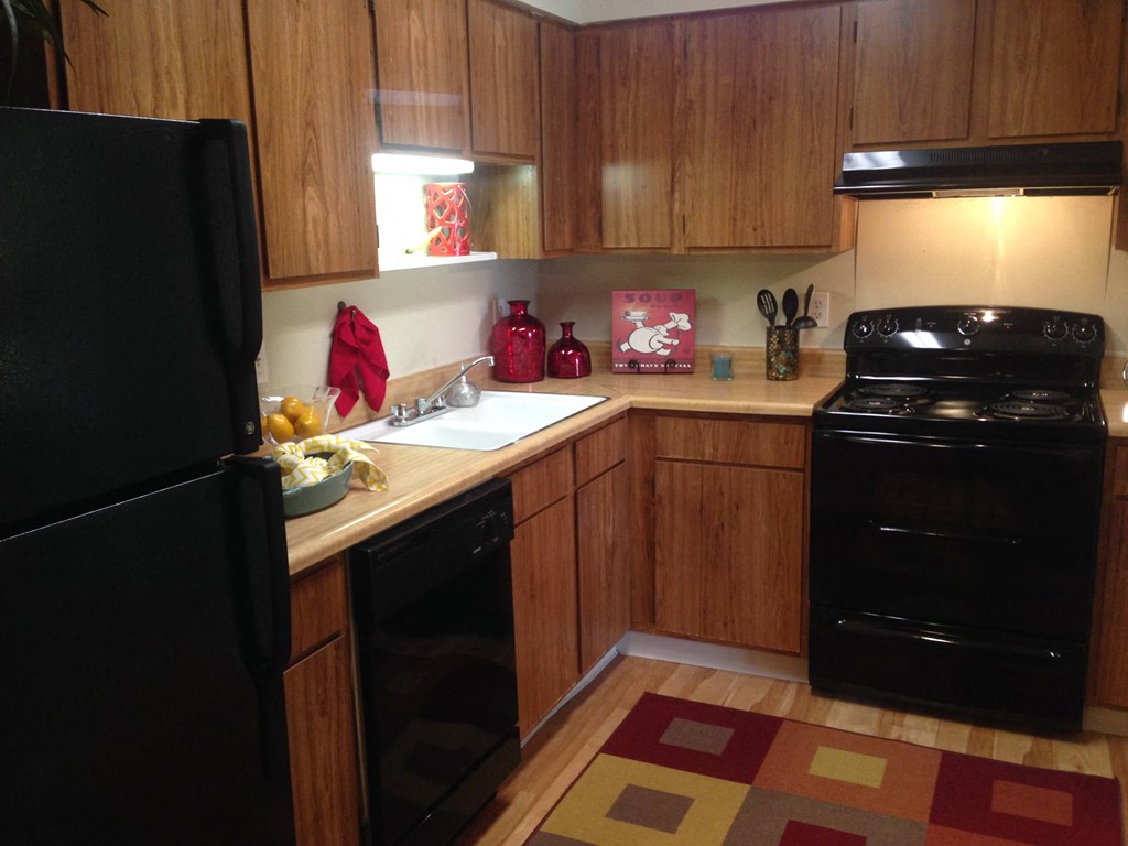 a kitchen with black appliances and wooden cabinets