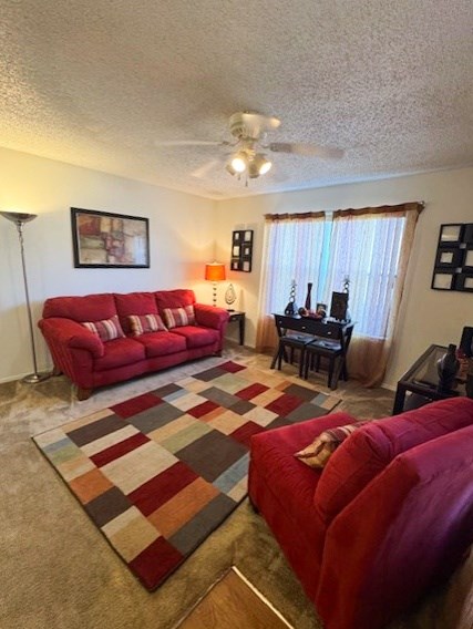 A living room with a red couch and a rug.