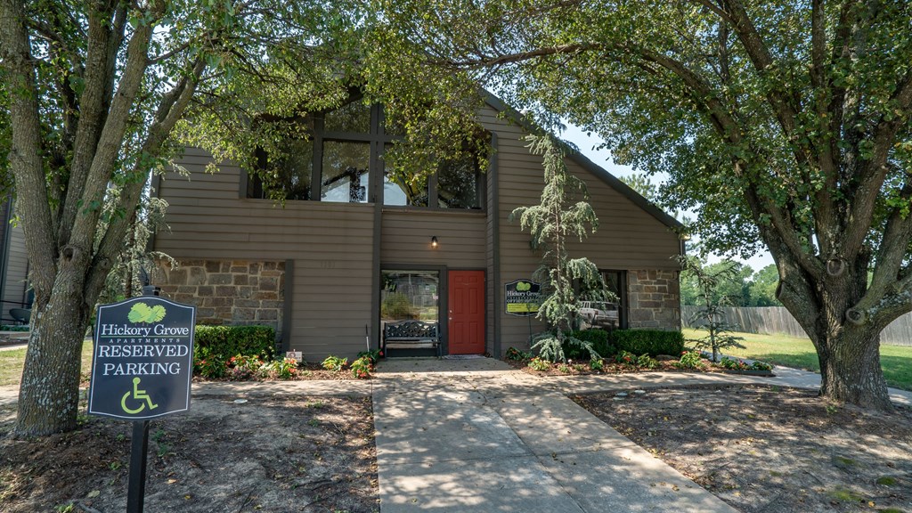 a building with a red door and a parking sign in front of it