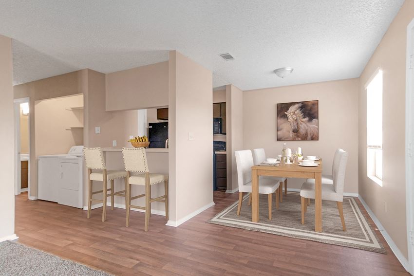 a living room and dining room with a table and chairs