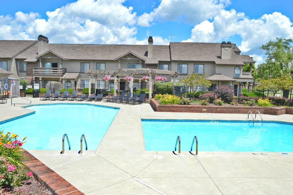 A large building with a pool in front of it.