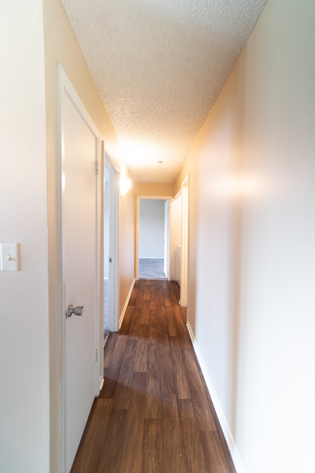 an empty hallway with wood floors and white walls and a view of the ocean