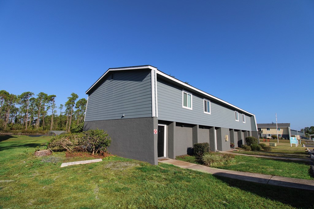 a grey building with a blue sky in the background