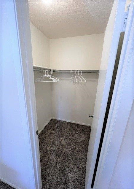 a small closet with white clothes hangers in it