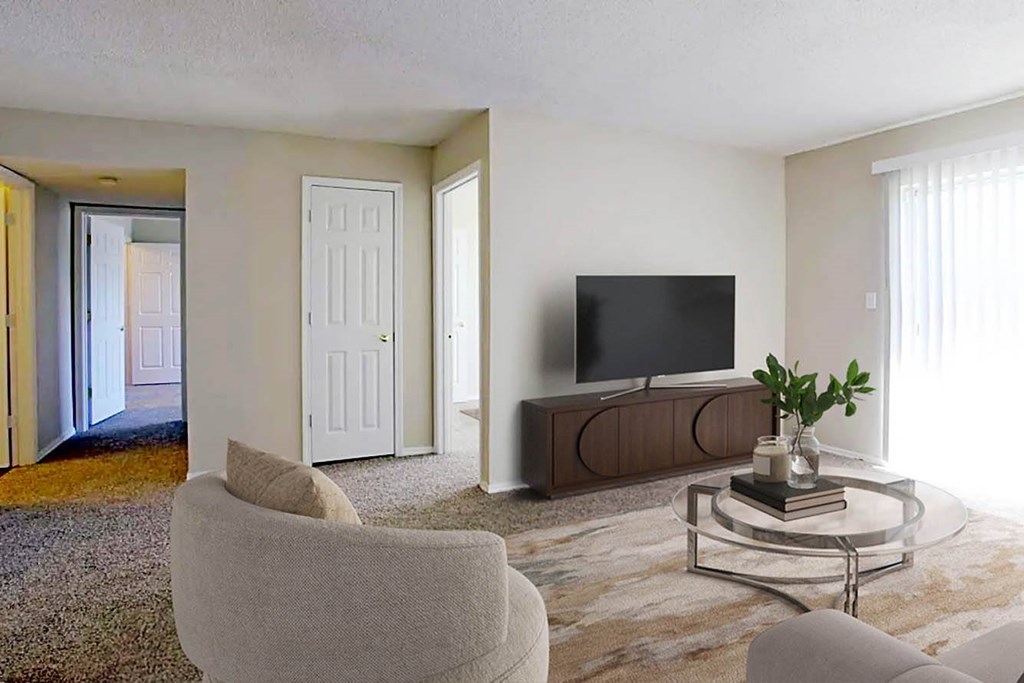 A living room with a television, a chair, and a table with a plant on it.