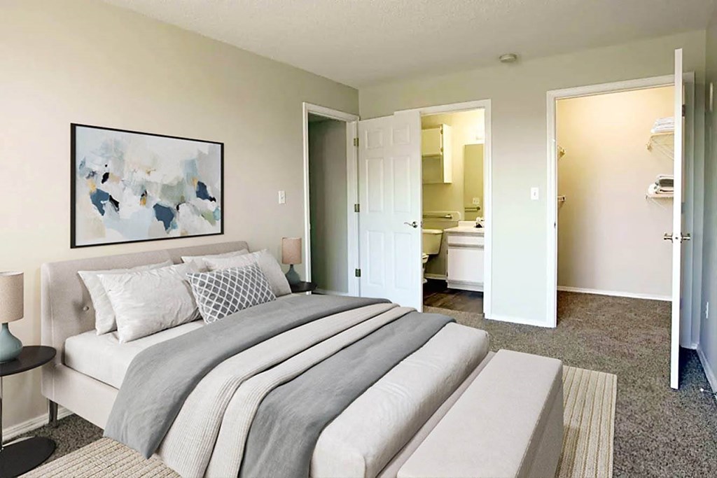 A bedroom with a large bed and a painting on the wall.