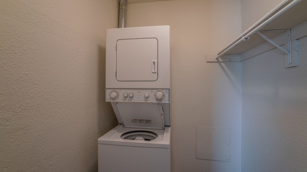 a bathroom with a toilet and a washer and dryer in it