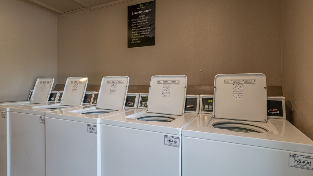 a laundry room with four washers and four washing machines